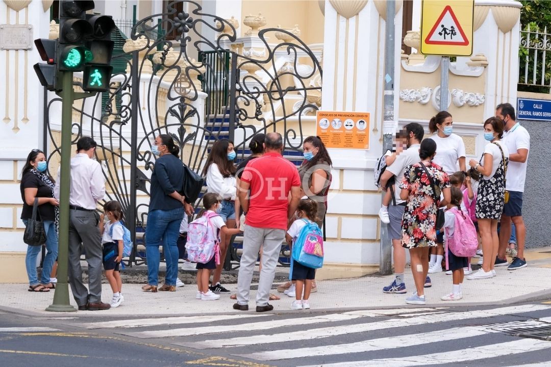 Niños y padres con mascarilla fuera de un centro escolar. / AH 