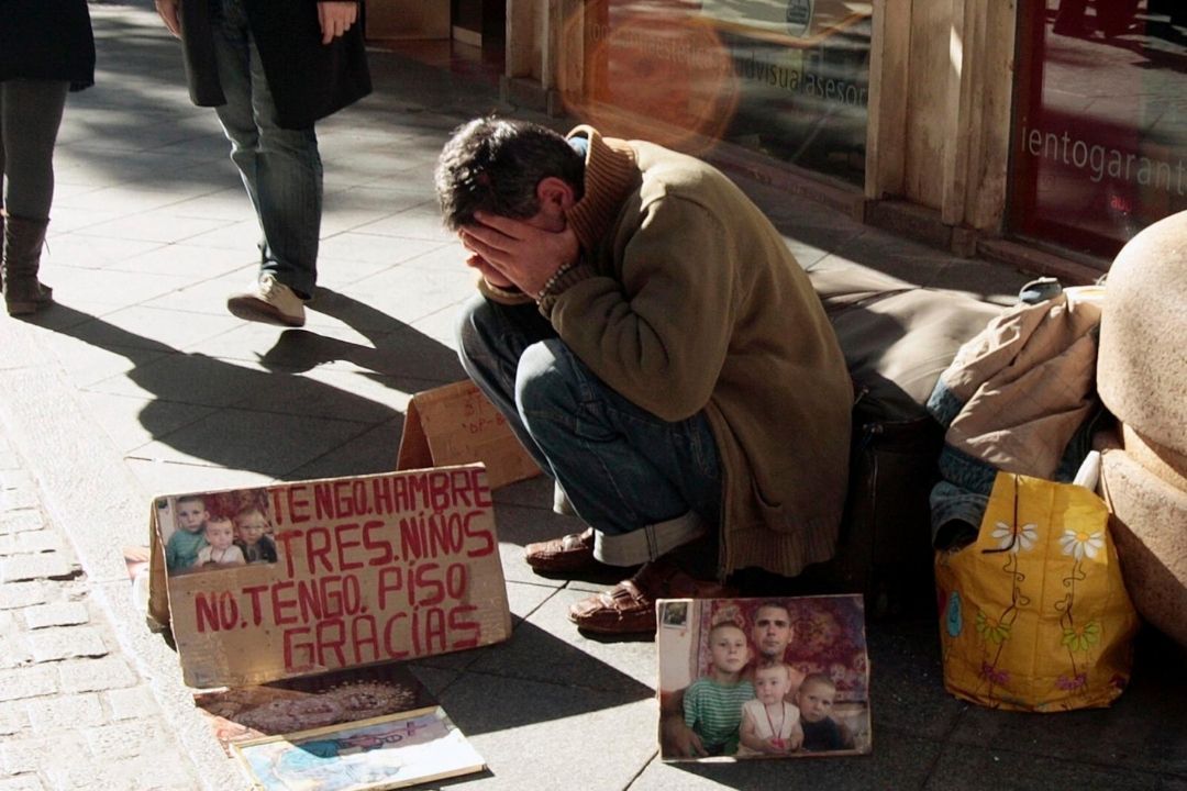 Un padre de familia pide dinero para sus hijos, víctimas de la pobreza infantil./ ARCHIVO