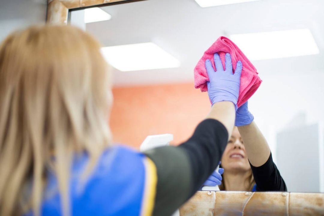 Imagen de una empleada del hogar limpiando un espejo. Efe