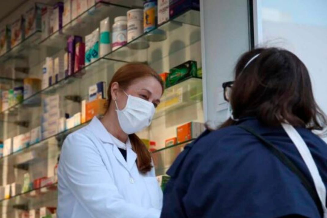 Usuaria en una farmacia con mascarilla./