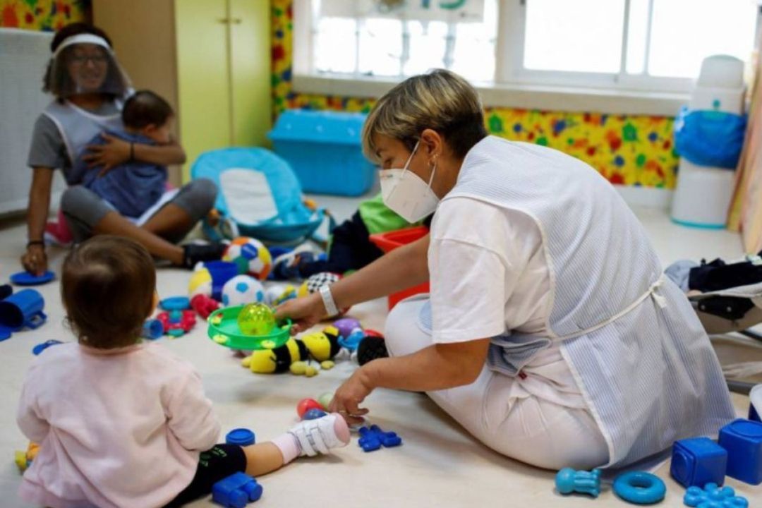 Profesora con alumnos de educación infantil de 0 a 3 años. /