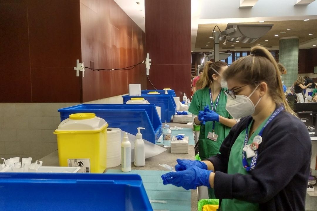 Sanitarias trabajando en un centro de vacunación. / 