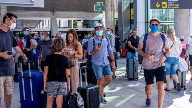 Turistas con mascarilla en un aeropuerto canario. / Archivo