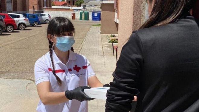 Una voluntaria de Cruz Roja entrega alimentos a una persona necesitada. / Archivo