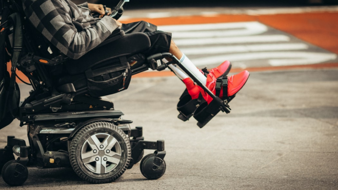 Un ciudadano con discapacidad transita en silla de ruedas por una calle. / Archivo