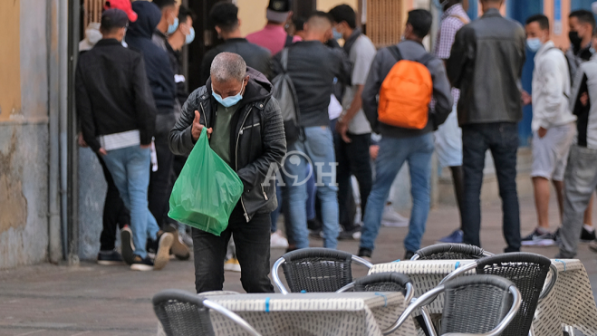 Un grupo de personas hacen cola para recibir comida. / AH