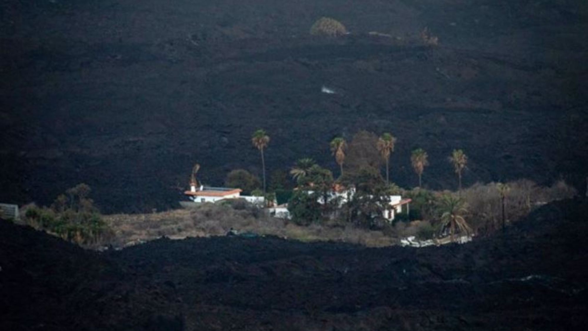 Una de las viviendas en el Valle de Aridane aún en pie rodeada de sedimentos del volcán. / EP