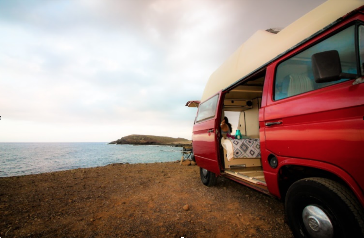Autocaravanistas estacionan frente a la costa en Canarias./ Camplify.