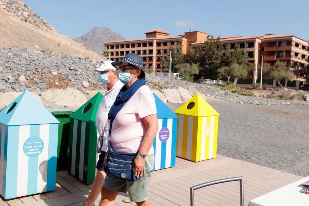 Dos turistas pasean por una playa de Canarias. / EFE