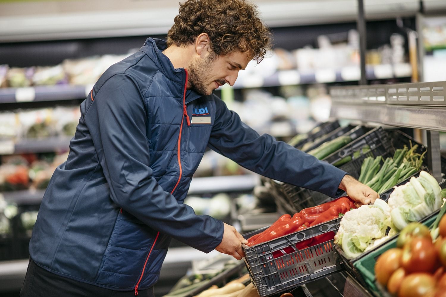 Un trabajador coloca unas cajas de tomates en un supermercado / Imagen distribuida por ALDI Un trabajador coloca unas cajas de tomates en un supermercado / Imagen distribuida por ALDI