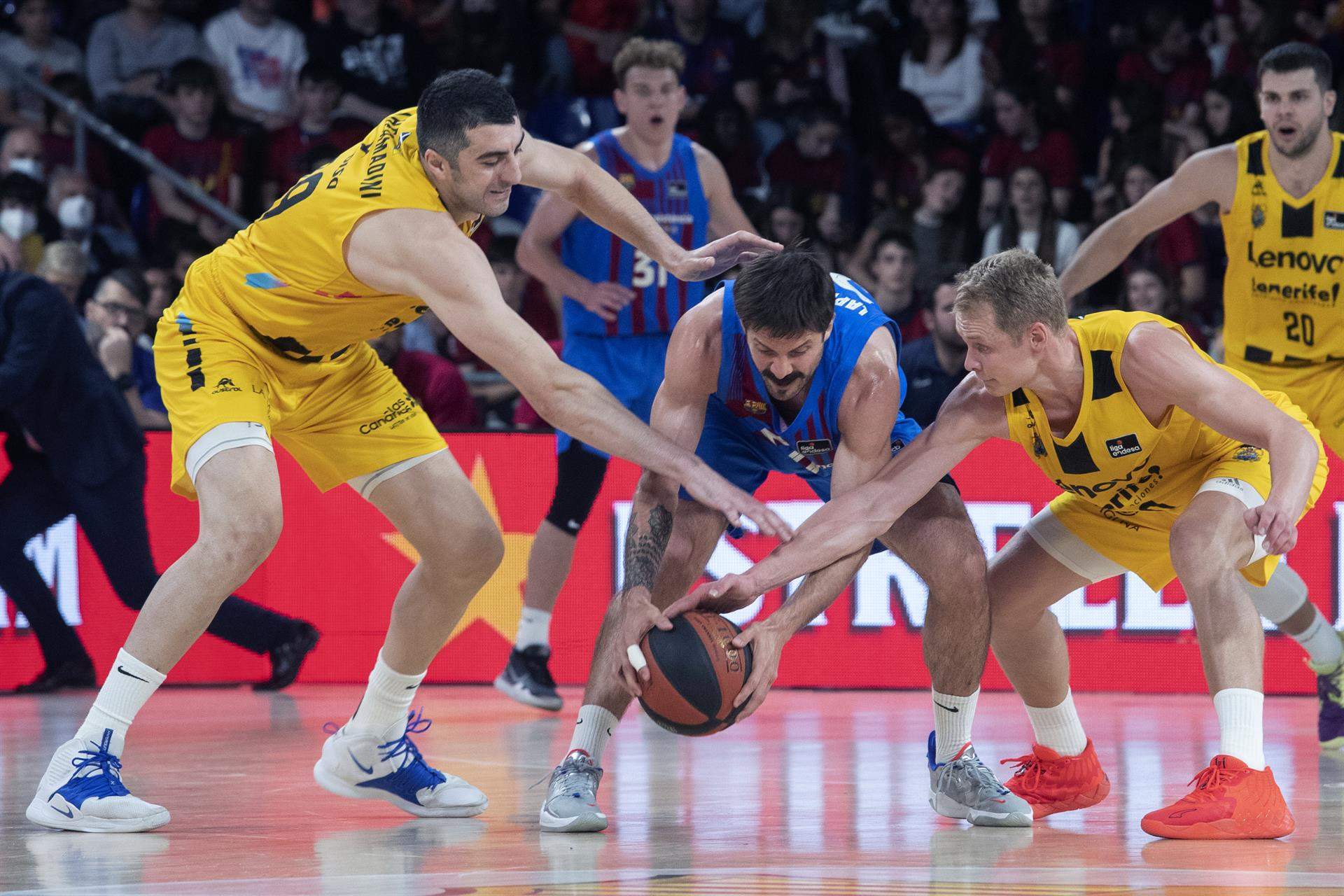 Los jugadores del CB Canarias, Gio Shermadini y Sasu Salin, disputan un balón al base del Barça, Nicolás Laprovittola./ Efe