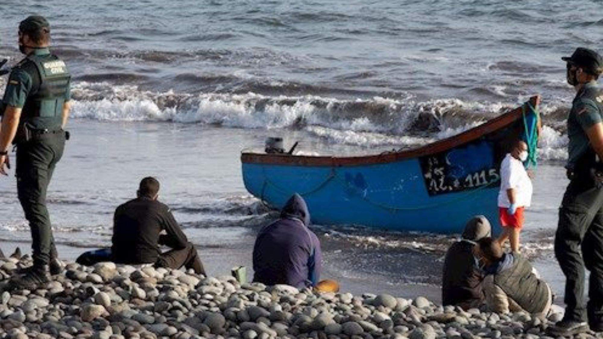 Personas migrantes junto a un cayuco en la costa. / EFE