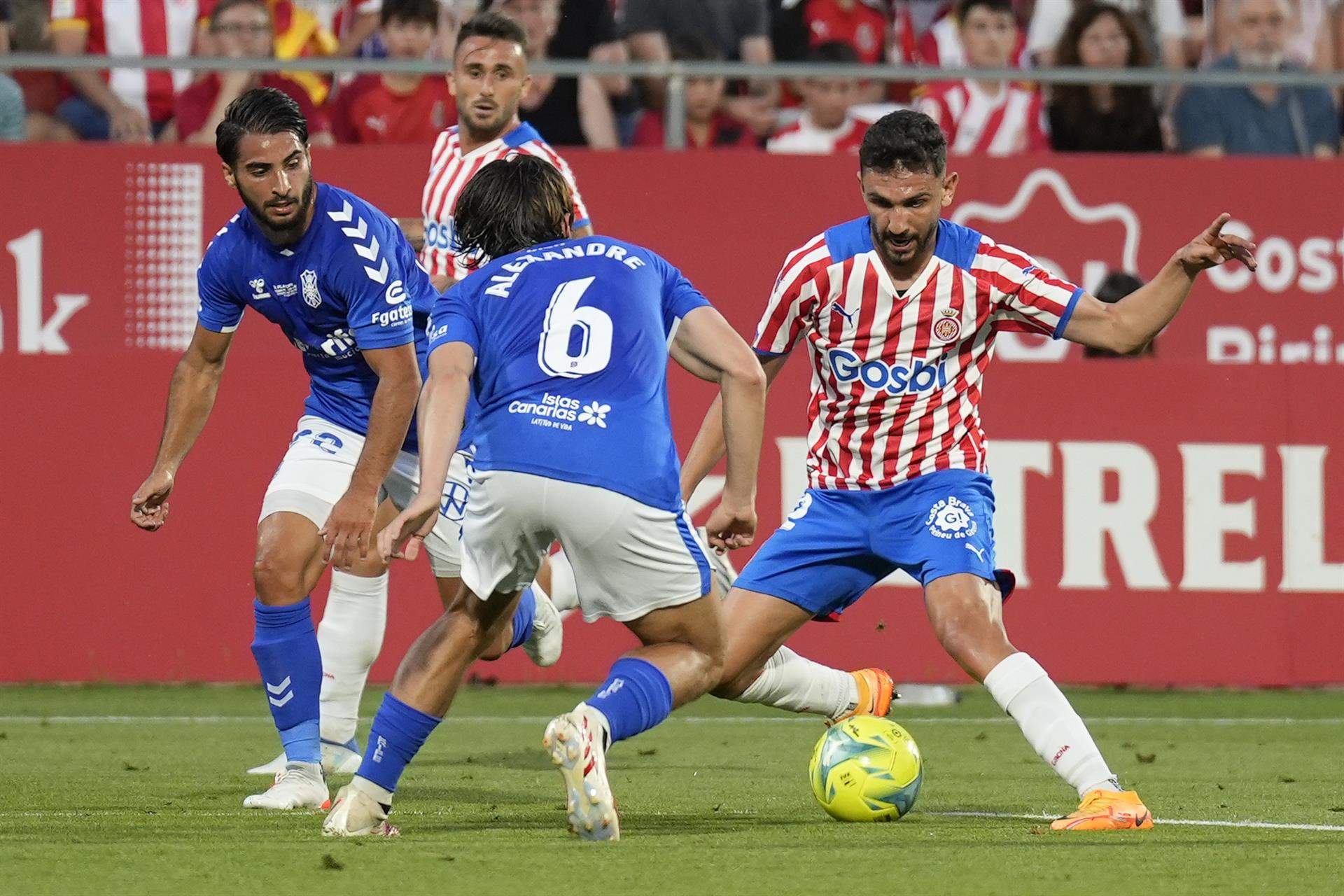 El centrocampista del Girona FC Iván Martín (d) juega un balón ante Alexandre Corredera, del CD Tenerife. EFE/David Borrat