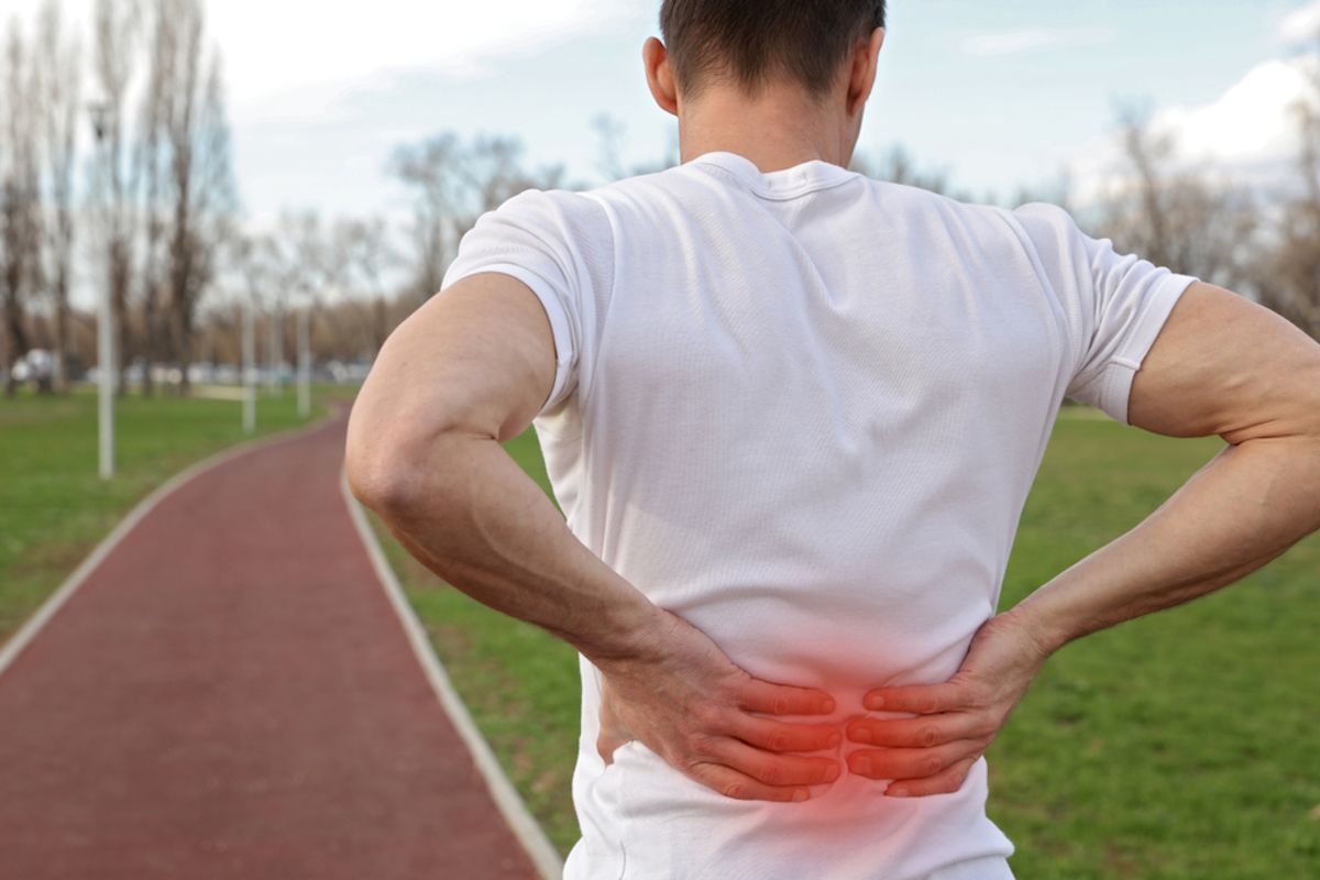 Un hombre se queja de un dolor lumbar mientras hace deporte: la hernia discal es muy incapacitante / QUIRÓNSALUD