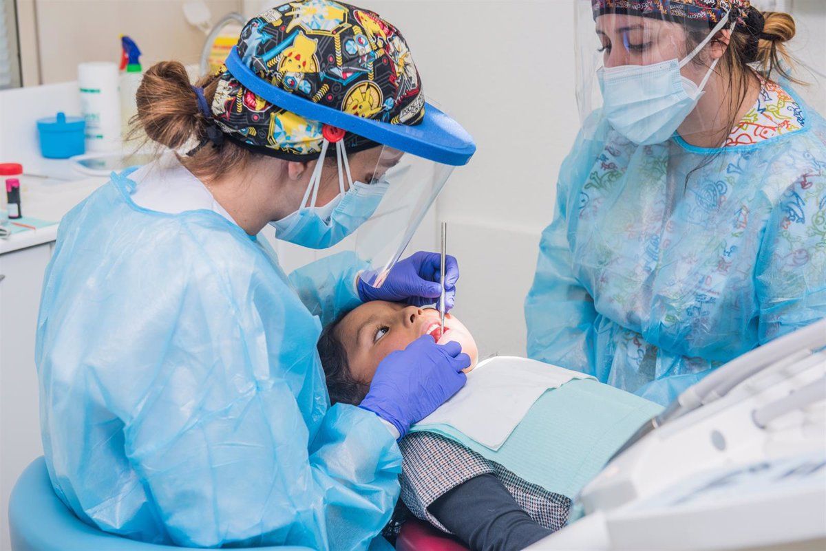 Dos dentistas atienen a un niño para mejorar su salud bucodental. / EP