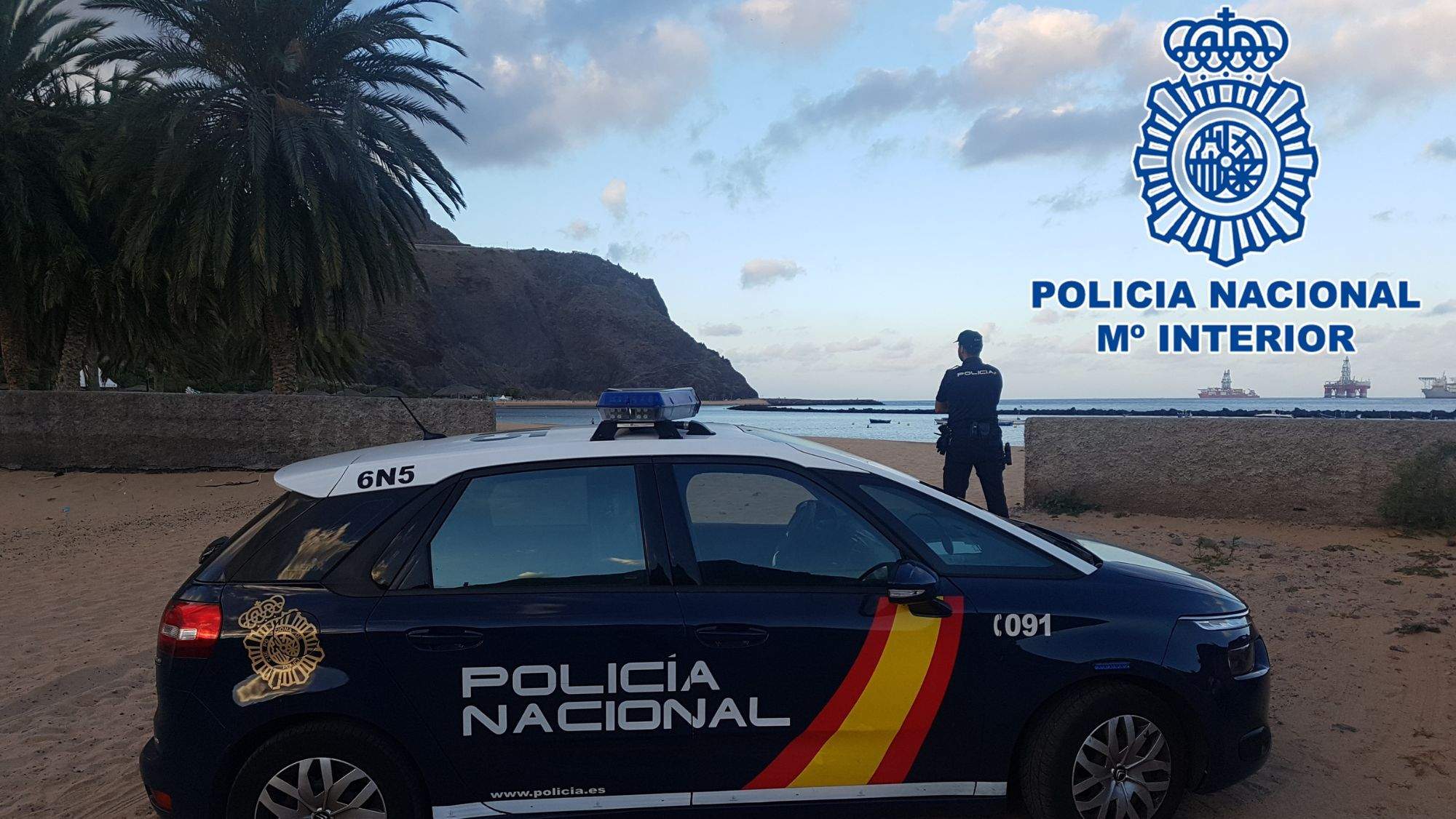 Un vehículo y un agente de la Policía Nacional en la costa de San Andrés. / Cedida