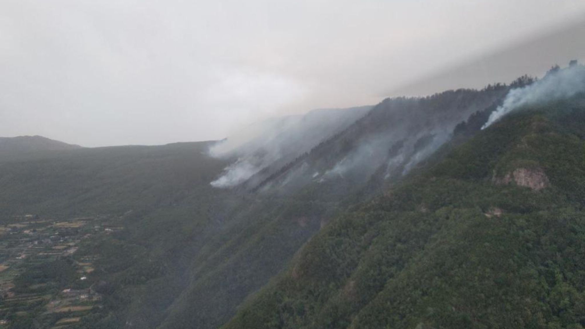 Un helicóptero de reconocimiento vigila las llamas en la ladera de Tigaiga. / 1-1-2 Canarias