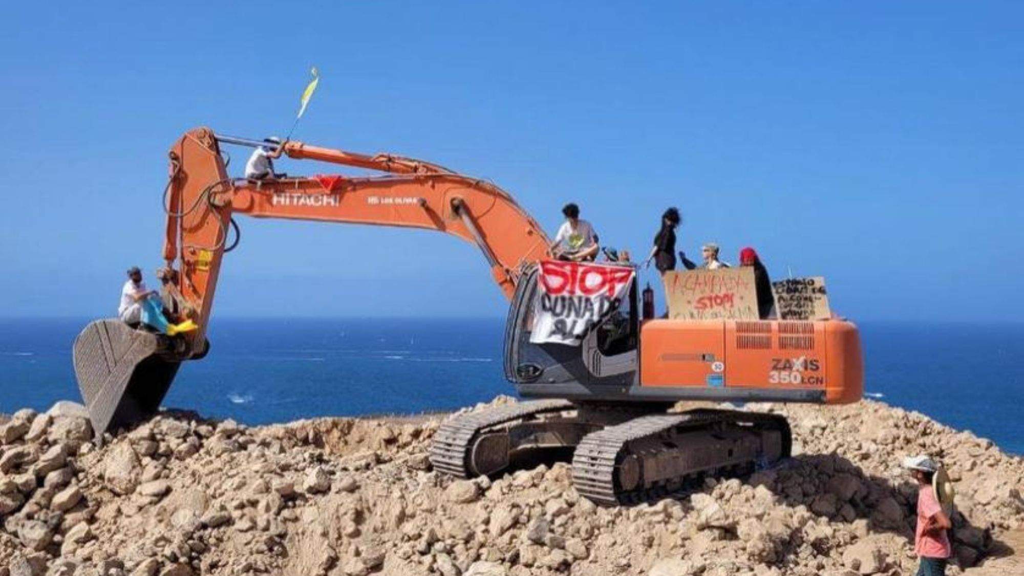Activistas protestan sobre una de las grúas que trabajan en el Puertito de Adeje. / @Salvarelpuertito
