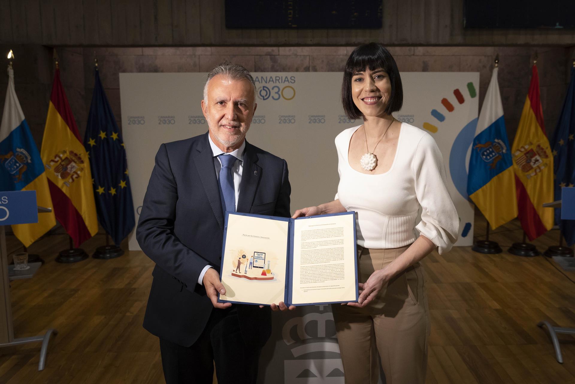 El presidente del Gobierno de Canarias, Ángel Victor Torres (i), y la ministra de Ciencia e Innovación, Diana Morant (d), posan con el documento firmado este jueves en Santa Cruz de Tenerife del Pacto por la Ciencia y la Innovación. EFE/ Miguel Barreto