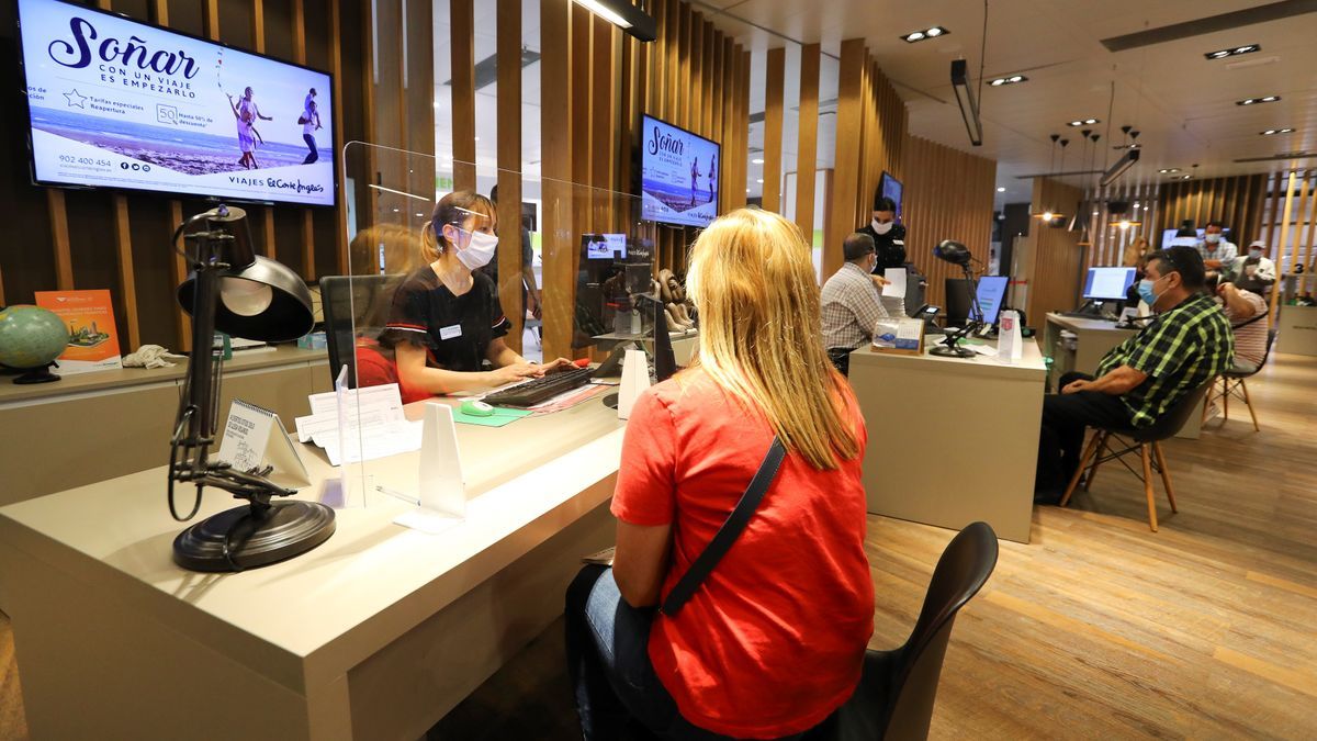 Imagen de trabajadores de una agencia de viajes atendiendo a sus clientes. / EFE Archivo 