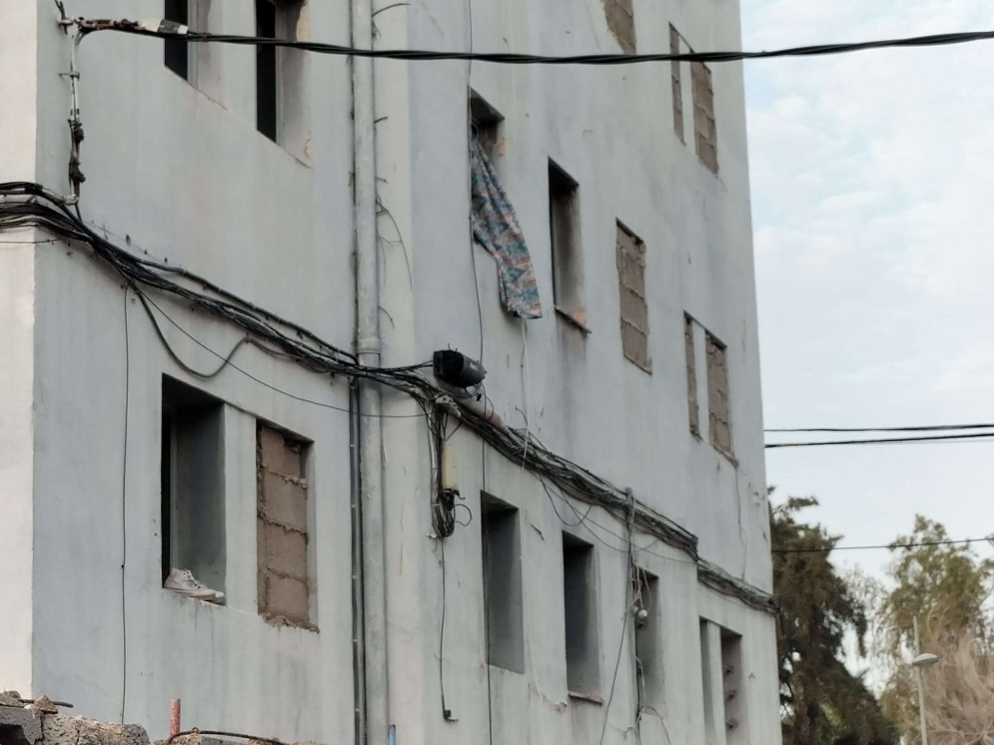 Unos tenis asoman por el alféizar de una de las ventanas que quedan todavía sin tapiar./ Álvaro Oliver (AH) Unos tenis asoman por el alféizar de una de las ventanas que quedan todavía sin tapiar./ Álvaro Oliver (AH)