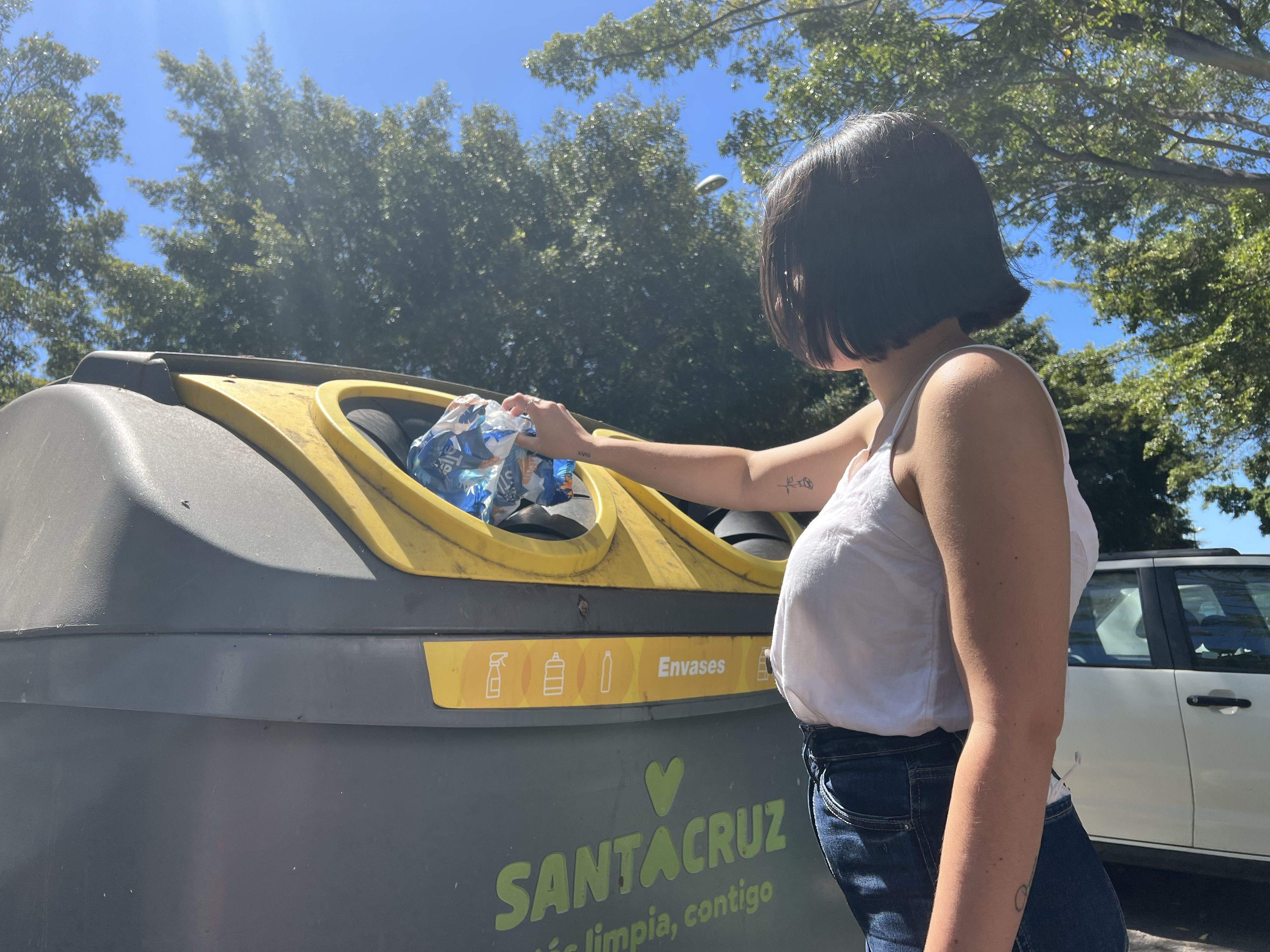 Una mujer reciclando residuos en contenedor amarillo./ Cedida