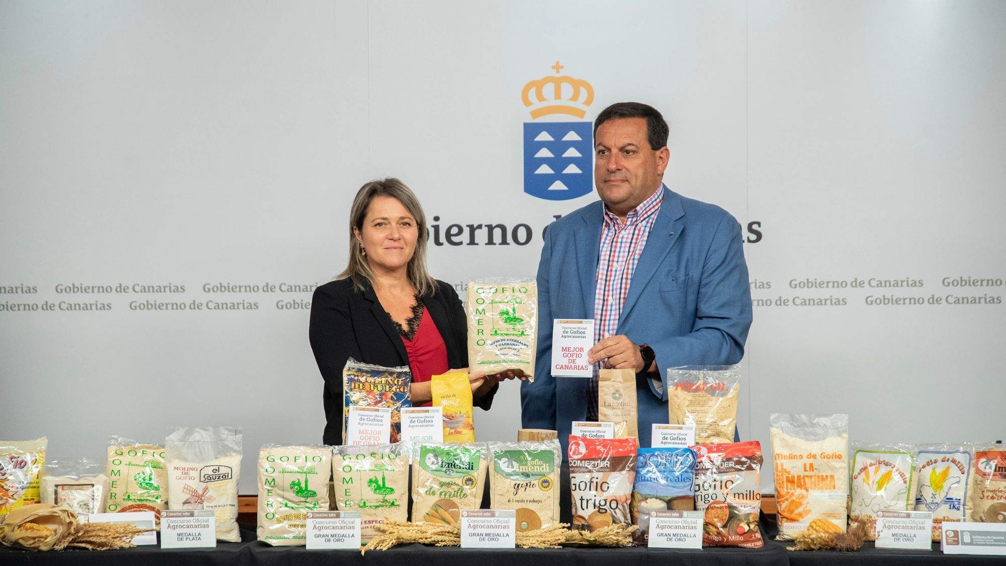 Rayco Herrera recoge de Alicia Vanoostende el premio mejor gofio de Canarias en el Concurso de Gofio Agrocanarias. / Cedida