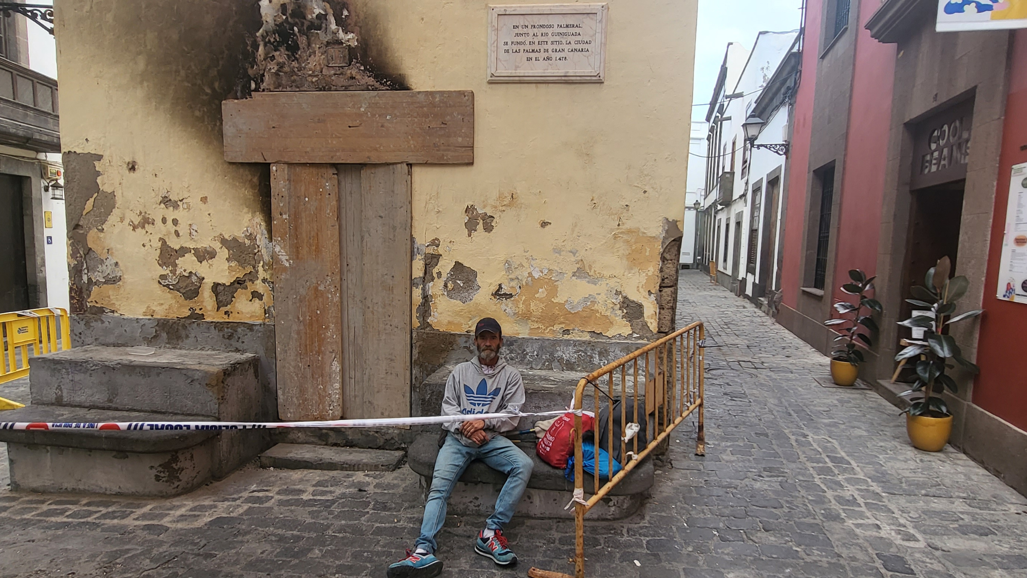 Manolo, uno de los hermanos junto a la puerta de la casa quemada. / Atlántico Hoy