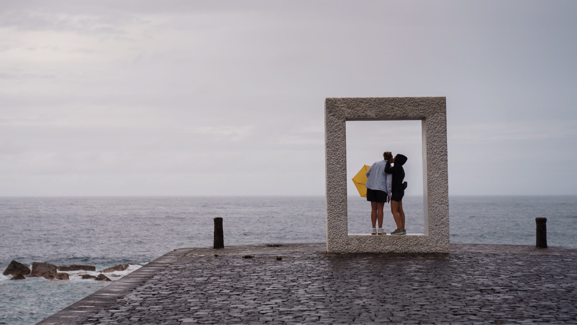 Dos personas disfrutan de un monumento en la costa de Garachico durante la alerta por la tormenta Hermine. / EFE-RAMON DE LA ROCHA