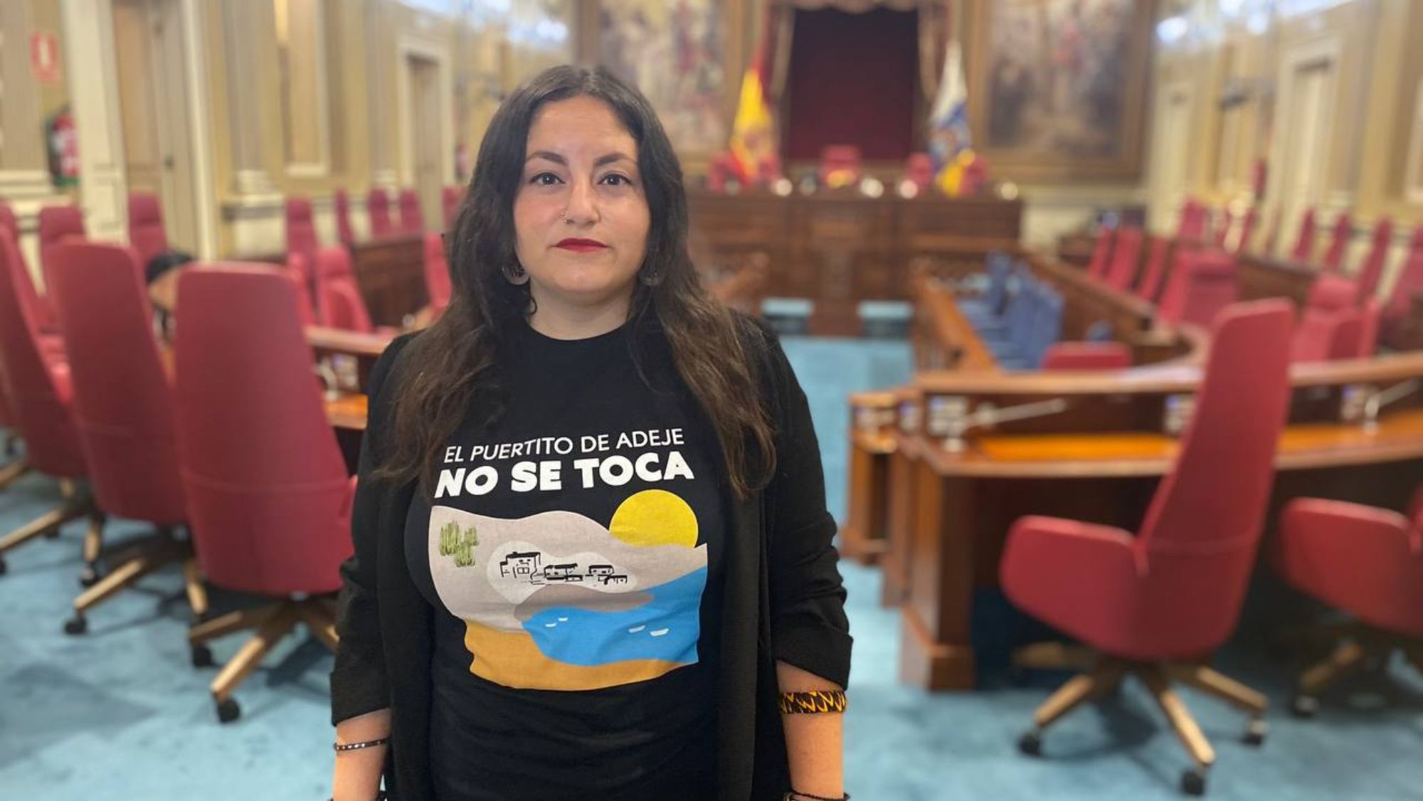Laura Fuentes, coordinadora general de Podemos Canarias, en el Parlamento luciendo una camiseta en defensa del Puertito de Adeje frente a las obras de Cuna del Alma. / Podemos Canarias Laura Fuentes, coordinadora general de Podemos Canarias, en el Parlamento luciendo una camiseta en defensa del Puertito de Adeje frente a las obras de Cuna del Alma. / Podemos Canarias