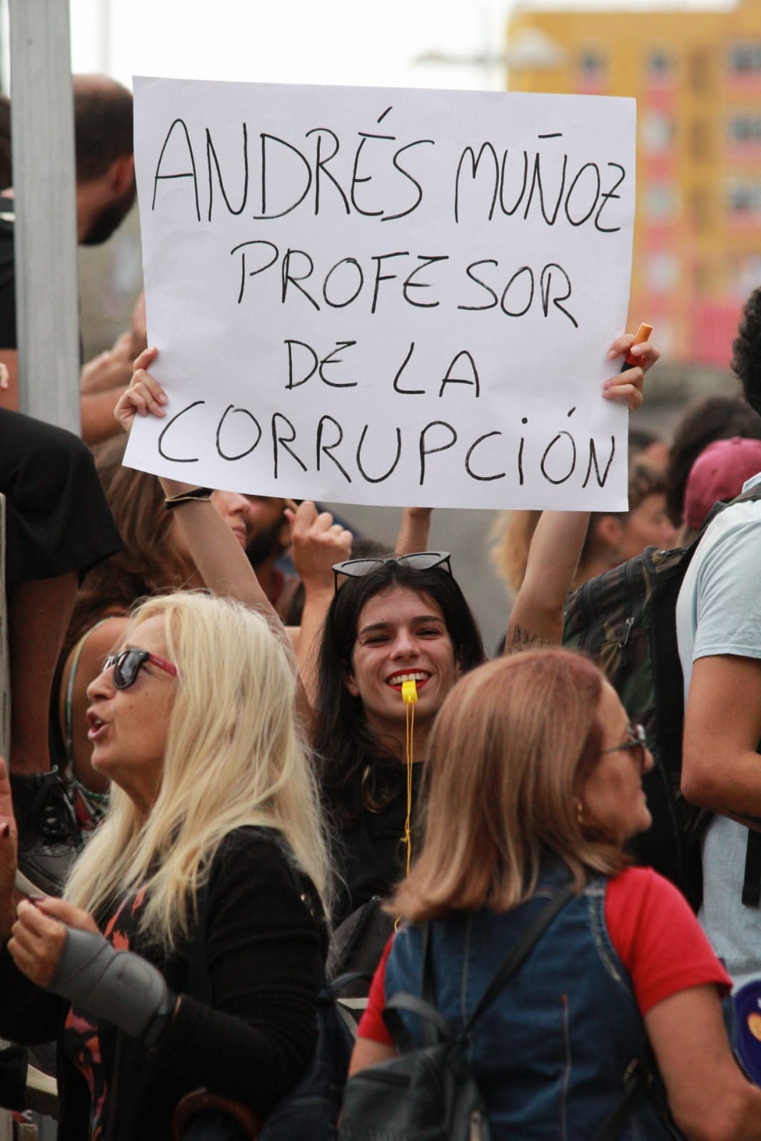 Una manifestante sostiene una pancarta contra Andrés Muñoz./ Álvaro Oliver (AH)