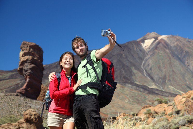 Unos turistas se hacen una foto junto a El Teide, en Tenerife./ Hosteltur