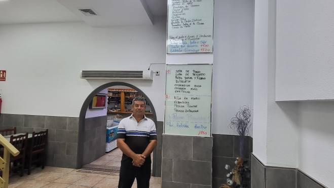 Braulio, propietario del Hermanos García junto a la pizarra con los menús.. AH