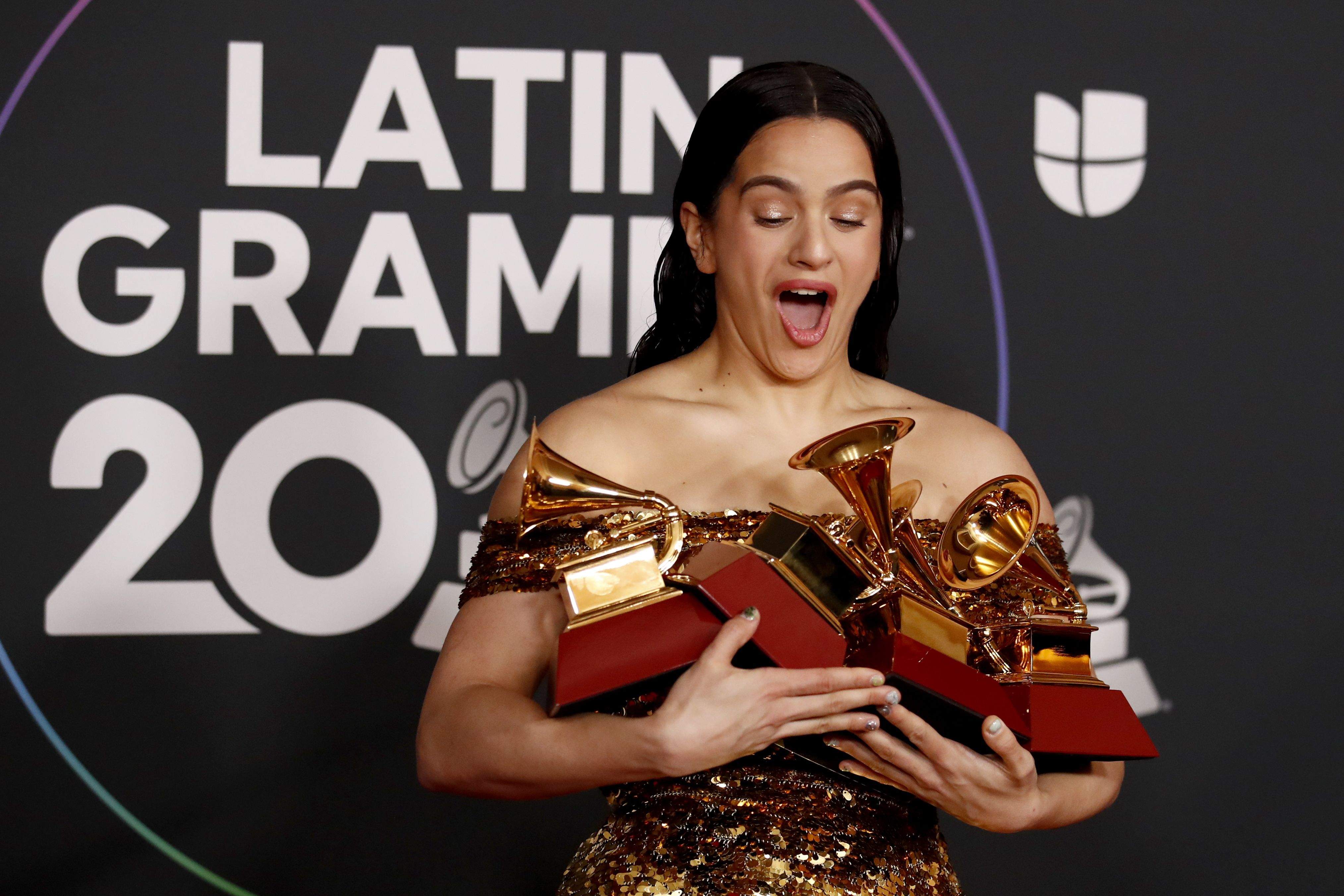 Rosalía sostiene sus cinco Grammy Latinos, uno de ellos ganado junto a El Guincho. / Caroline Brehman (EFE)