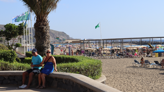 Dos turistas sentados en el paseo de Los Cristianos, en el sur de Tenerife (Canarias)./ Atlántico Hoy 