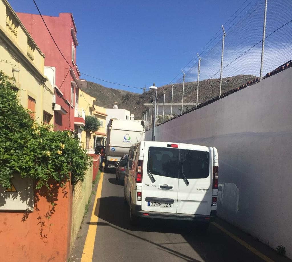 Un camión de la basura parado en un garaje para poder salir y el tráfico en la calle El Cañaveral. / AH