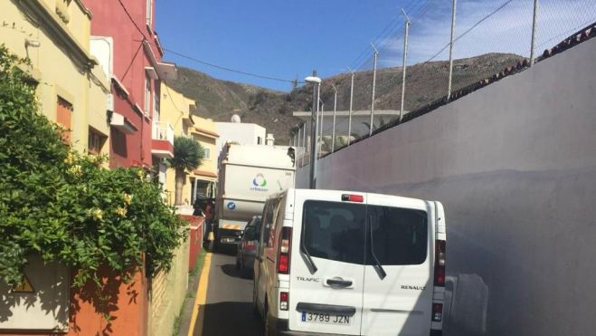Un camión de la basura parado en un garaje para poder salir y el tráfico en la calle El Cañaveral. / AH