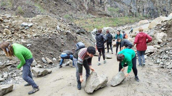 Personas intentando despejar las carreteras para que puedan pasar las guaguas y vehículos. /Cedida