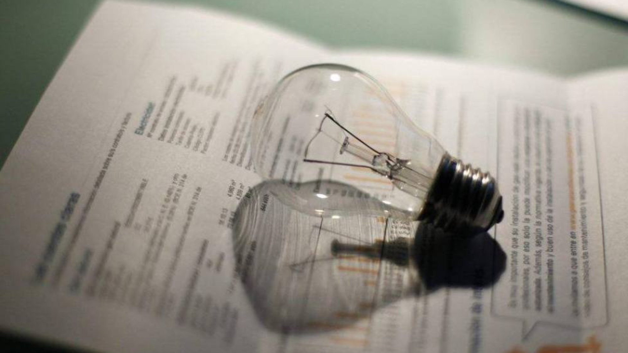 Factura de la luz junto a una bombilla. / EFE