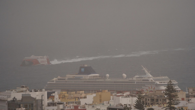 Un barco de pasajeros llega al puerto de Santa Cruz de Tenerife, cubierta por la calima procedente del continente africano. EFERamón de la Rocha