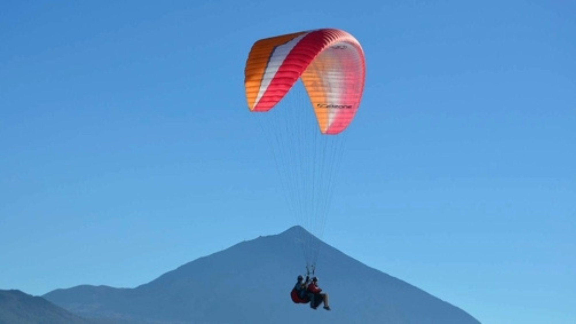 Unos parapentistas en Tenerife con el Teide al fondo./ Tenerfly
