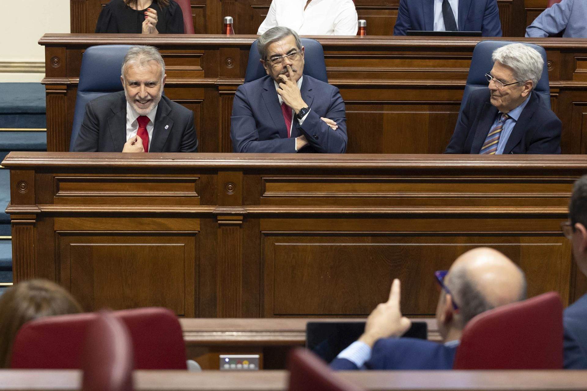 Ángel Víctor Torres, Román Rodríguez y Julio Pérez, en el Parlamento, en la bancada del Gobierno de Canarias, durante una jornada del debate de la nacionalidad. / EFE / MIGUEL BARRETO