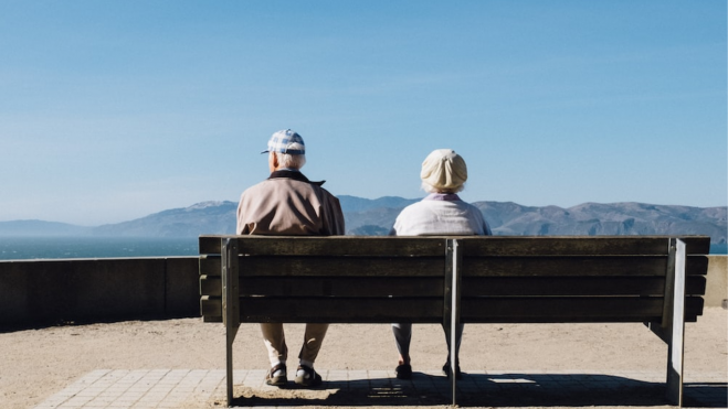 Imagen de dos personas mayores sentadas en un banco./ Unplash