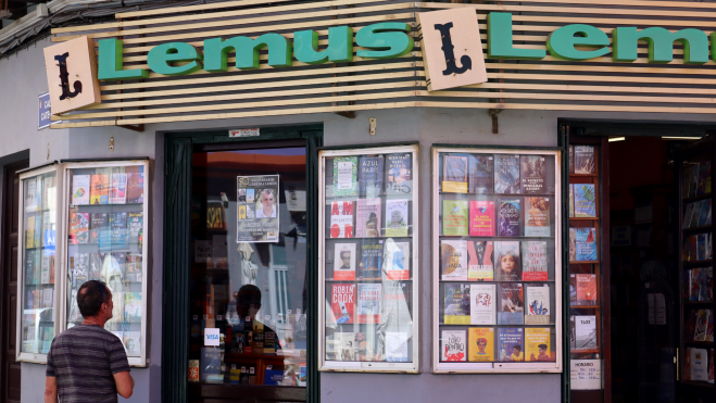 Un hombre observa uno de los escaparates de la librería Lemus. / Ainoha Cruz