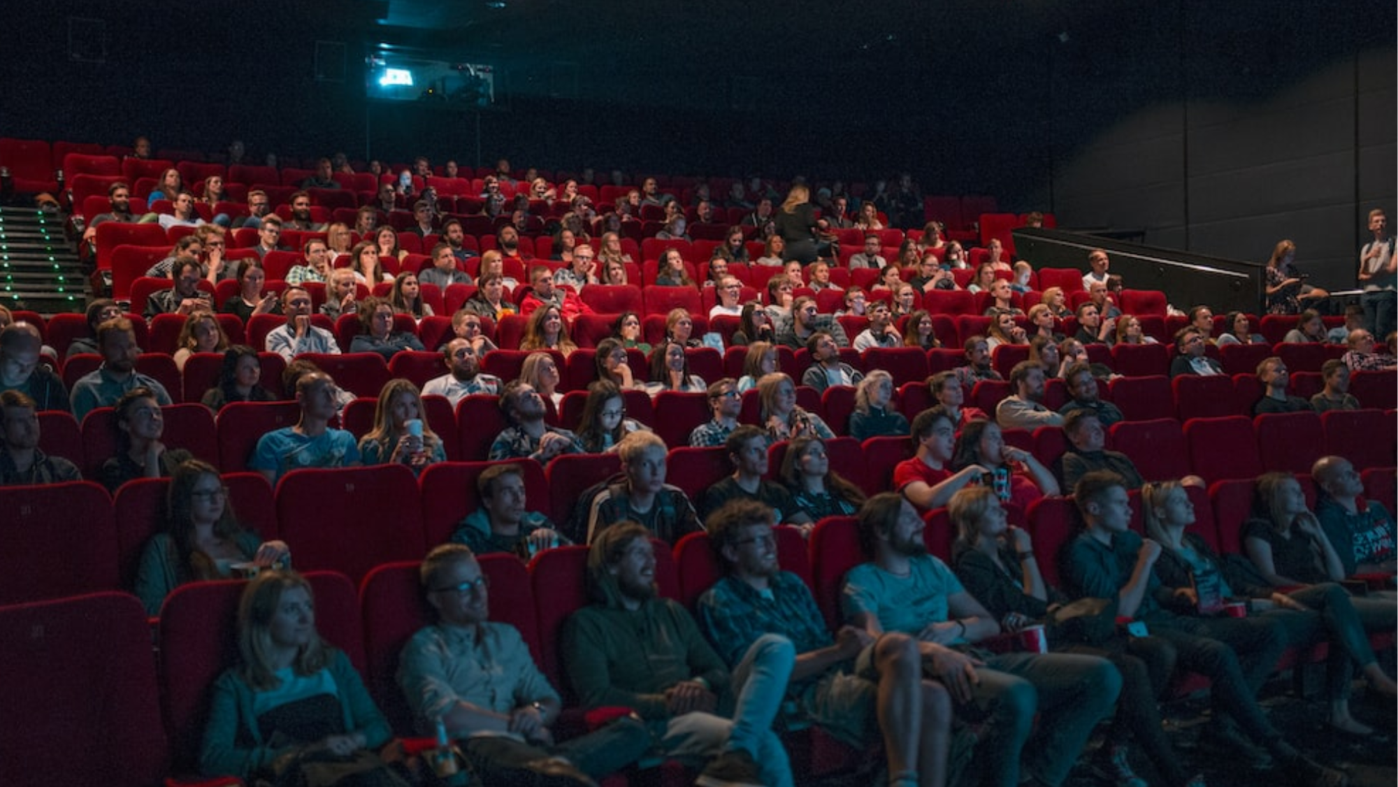 Imagen de personas viendo una película en el cine./ Unplash