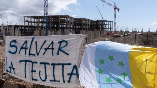 Protestas de los activistas de Salvar La Tejita en el hotel que se está construyendo en Granadilla de Abona. / EFE