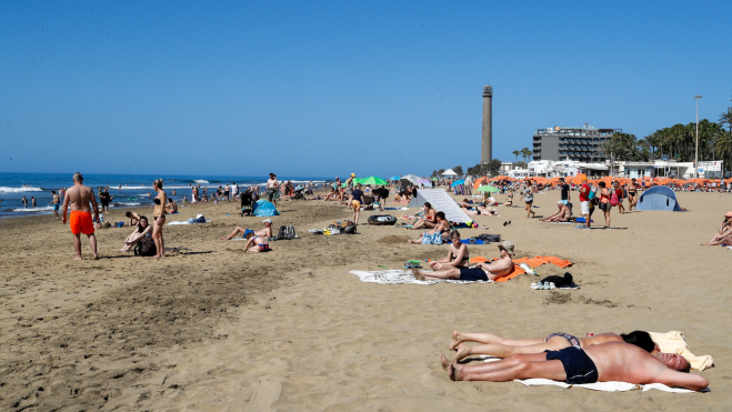 Turistas tomando el sol en Playa del Inglés / ELVIRA URQUIJO - EFE 