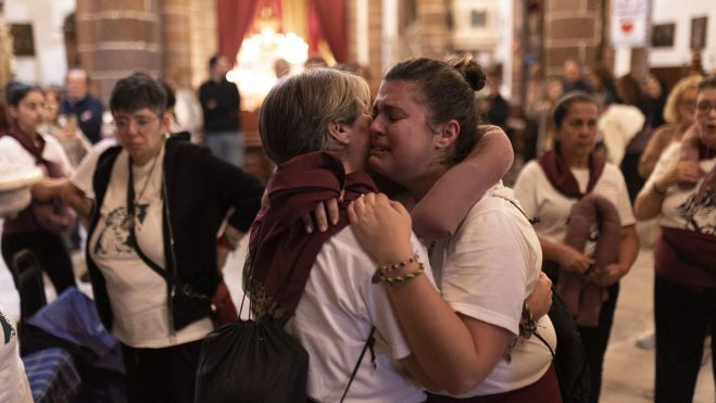 Dos mujeres costaleras se abrazan emocionadas tras la procesión del Jesús Cautivo / EFE - MIGUEL BARRETO