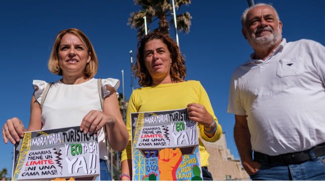 Noemí Santana (izquierda) acudió a la manifestación para exponer la necesidad de implantar una ecotasa en Canarias / ÁNGEL MEDINA G. - EFE