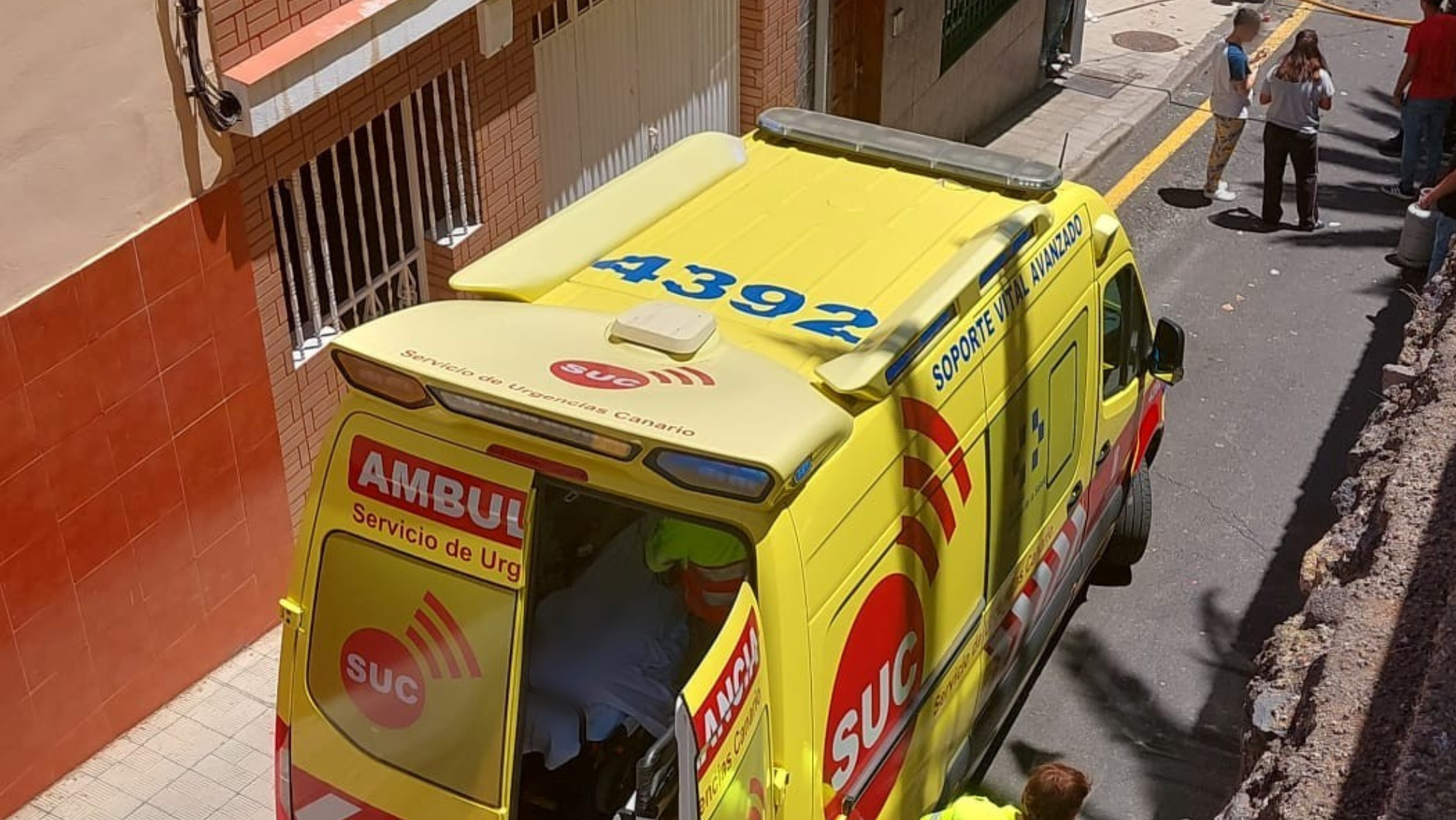Una ambulancia atendiendo a una mujer herida tras la explosión de una bombona en Santa Cruz de Tenerife. / 112